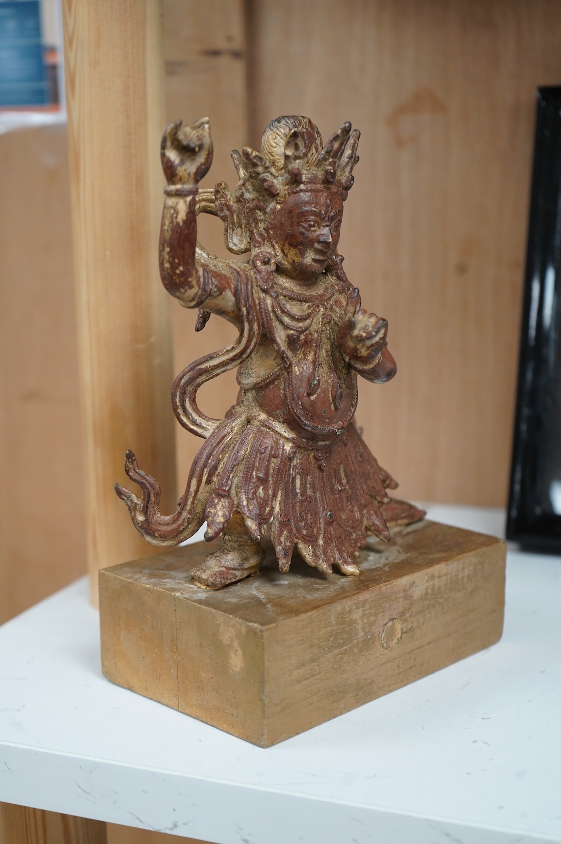 A Buddhist gilt bronze figure of Vaishravana, possibly Tibetan, 21 cm including wooden stand.